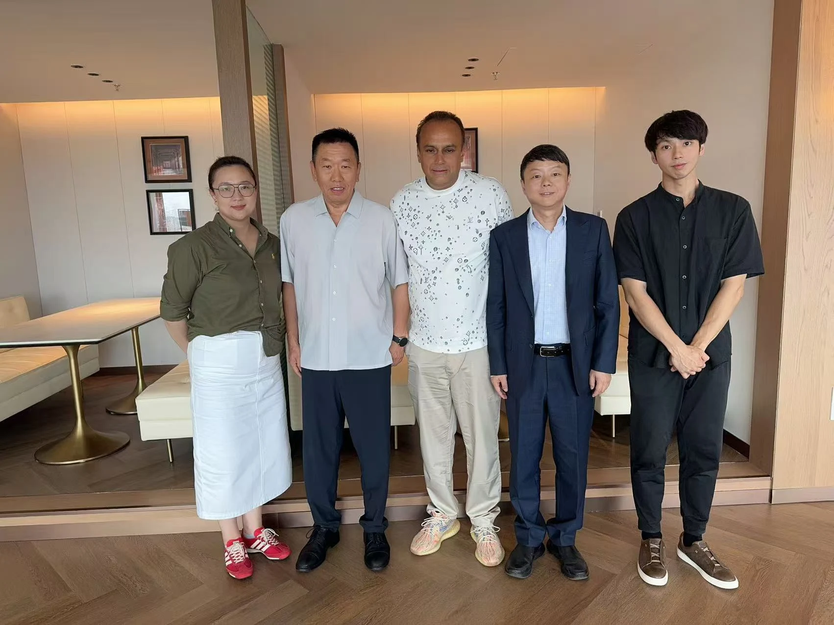 Zhang with a visiting business group during an indoor reception in China.