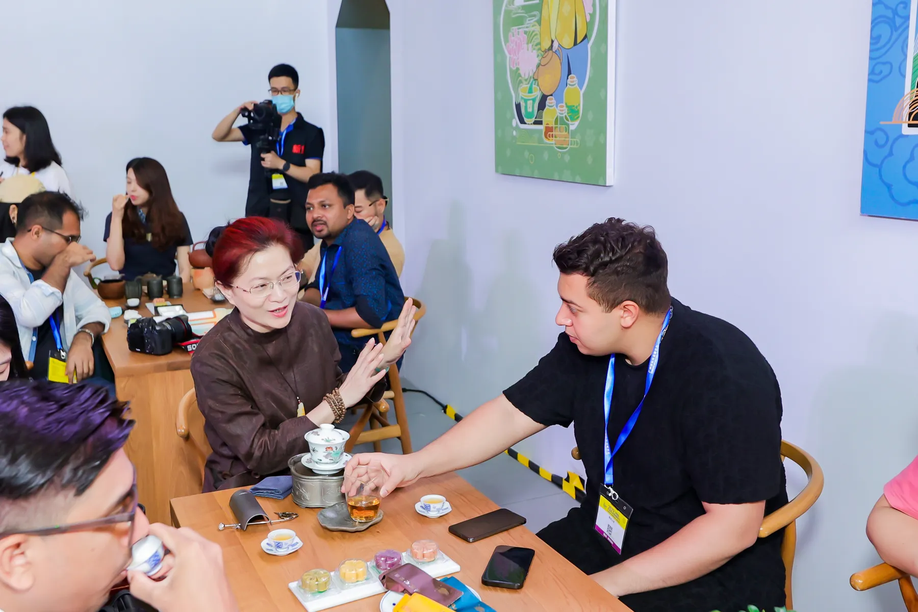 A tea facilitator explaining Chinese tea to seated visiting delegates in Guangzhou