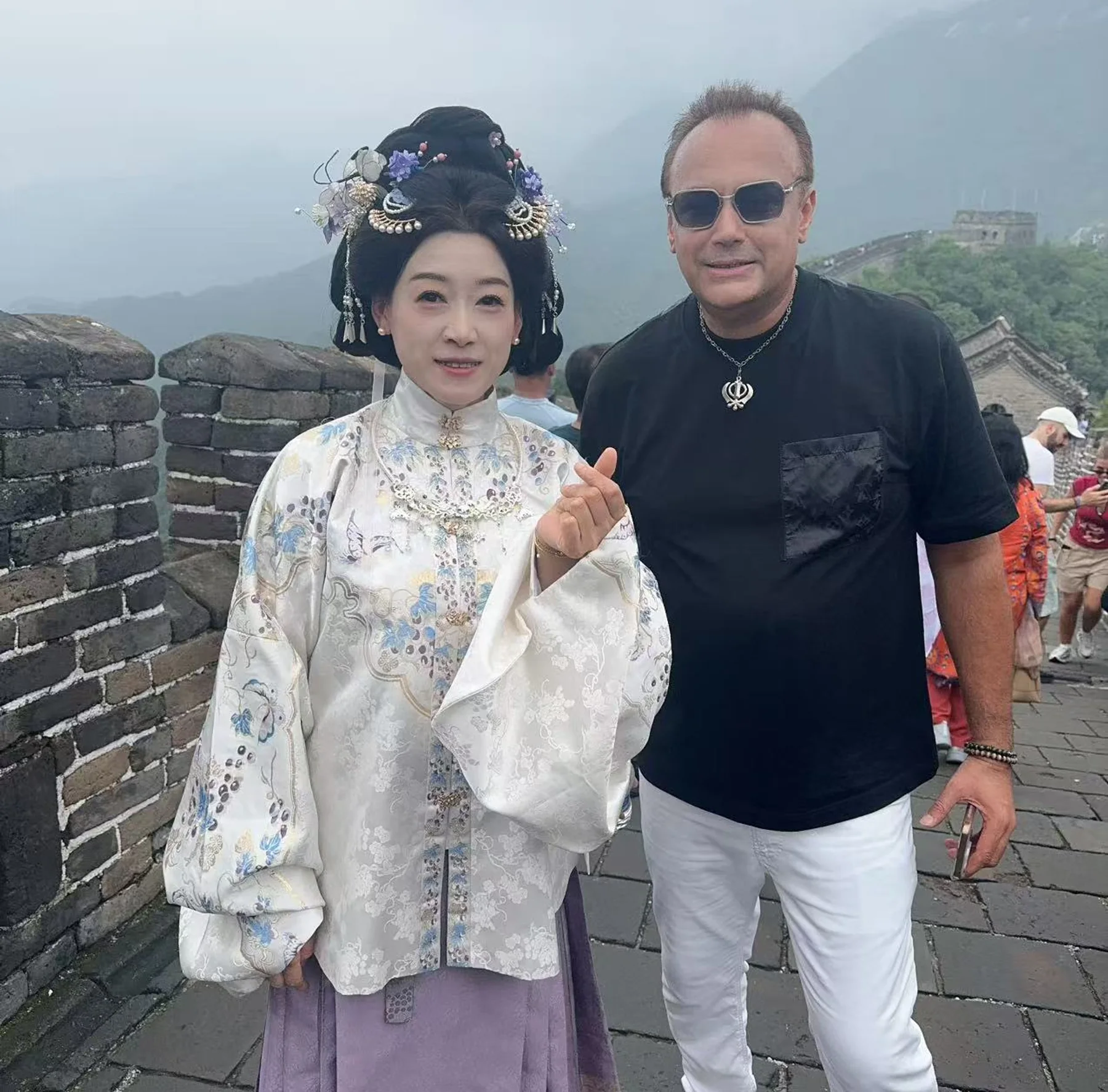 Two people at the Great Wall, one wearing traditional-style Chinese clothing.